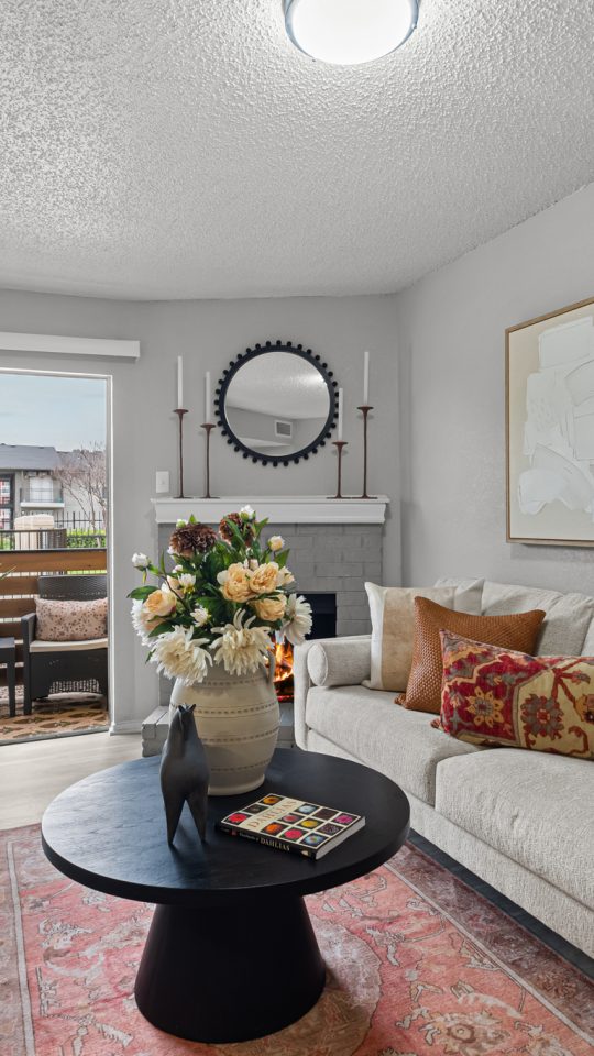a living room with a couch, coffee table and a sliding glass door at The  Dahlia