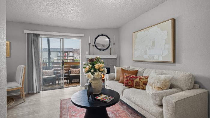 a living room with a couch, coffee table and a sliding glass door at The  Dahlia