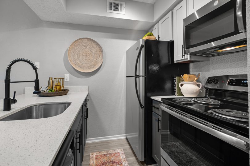 kitchen with stainless steel appliances and black counter tops at The  Dahlia