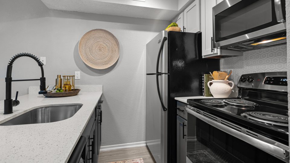 kitchen with stainless steel appliances and black counter tops at The  Dahlia
