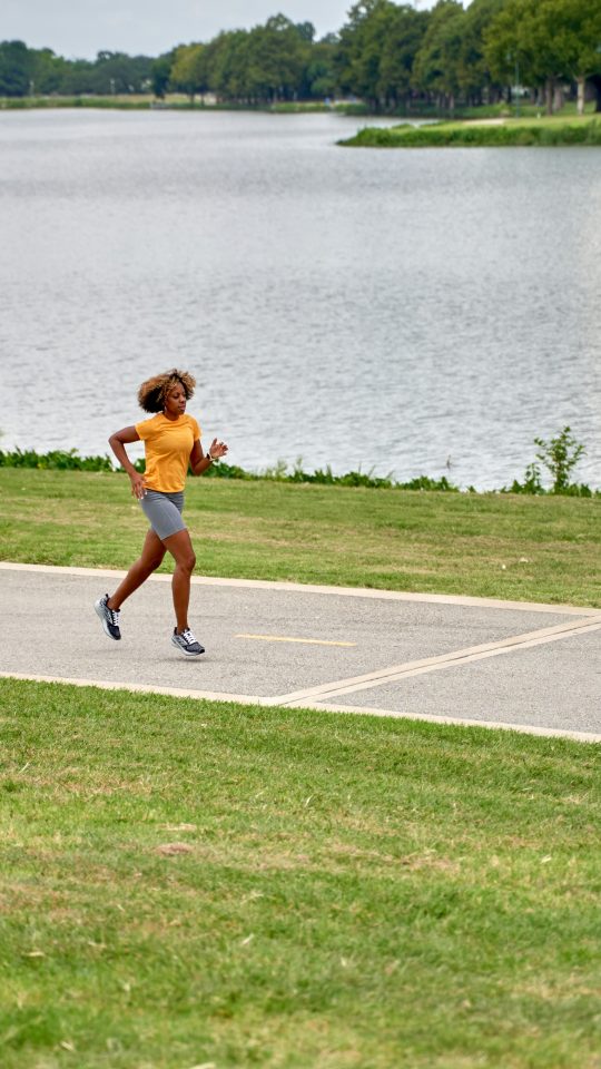 a person running on a path near a body of water